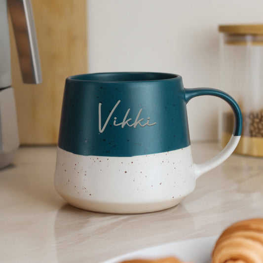 Personalised Blue and white speckled mug with 'Vikki' on a kitchen counter