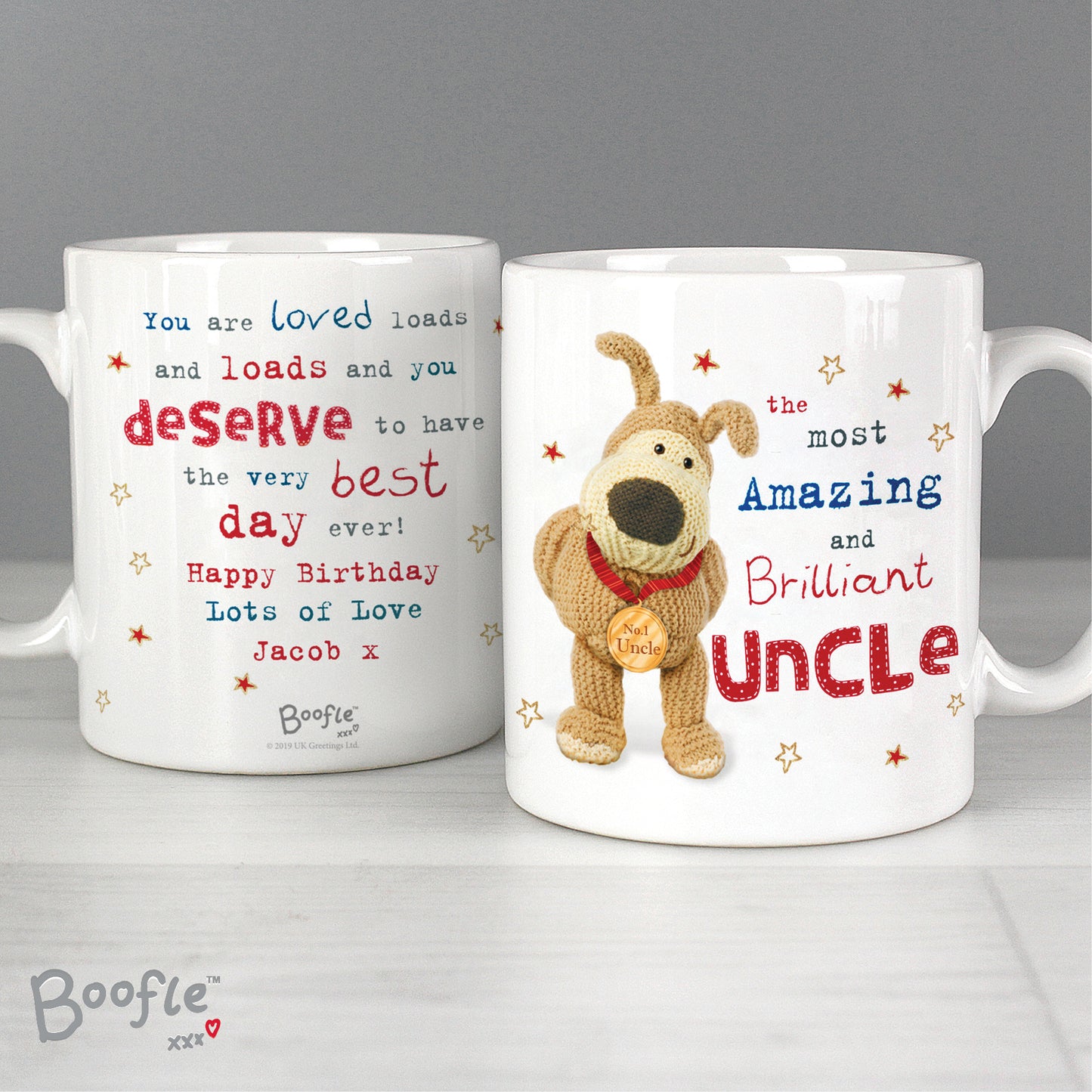 Two white mugs with coloured print on a white shelf