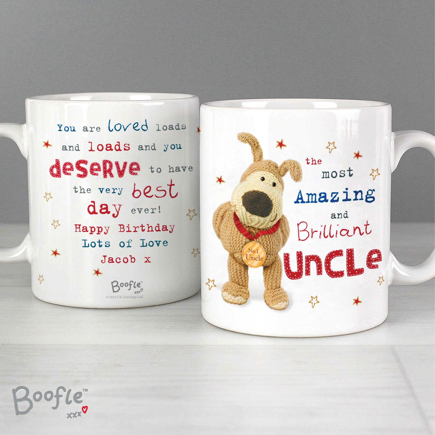 Two white mugs with coloured print on a white shelf