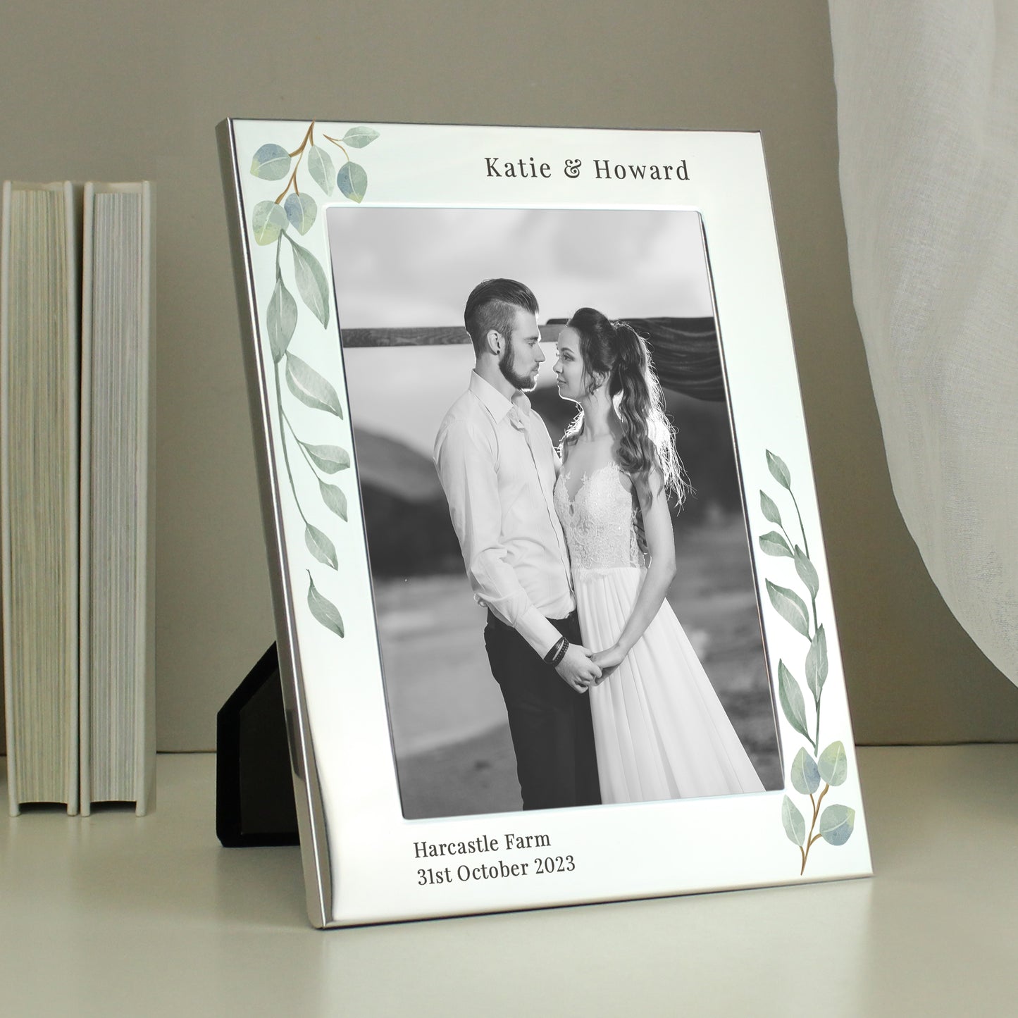 A silver 5x7 photo frame with a botanical design, personalised with a message, displaying a couple's wedding photo.