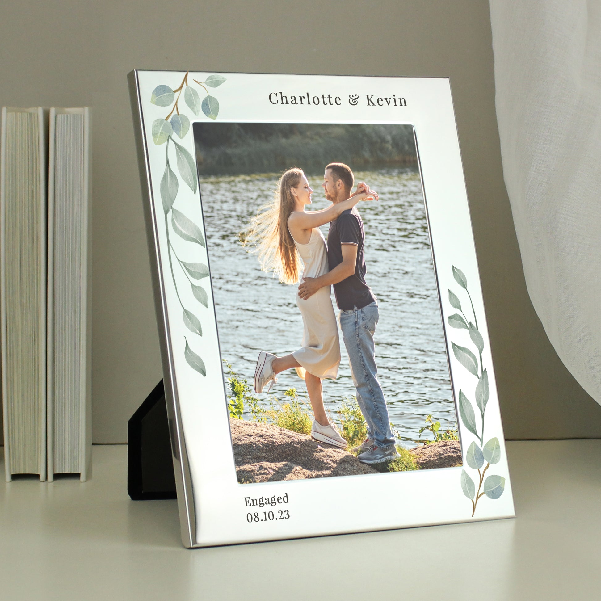 A silver 5x7 photo frame with a botanical design, personalised with a message, displaying a couple's wedding photo.