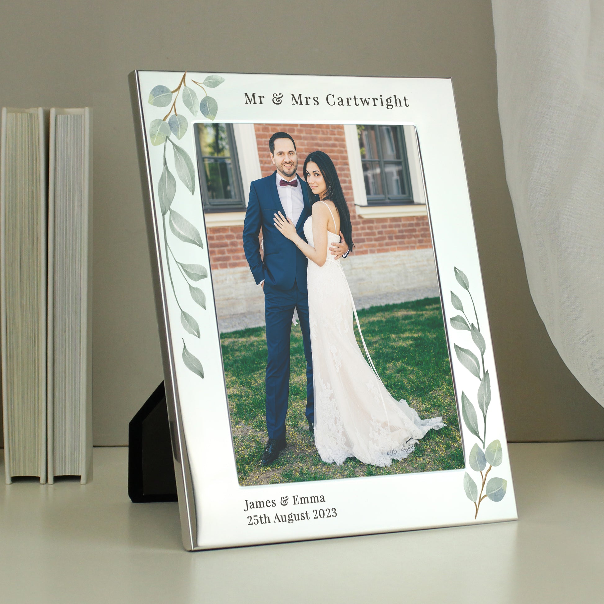 A silver 5x7 photo frame with a botanical design, personalised with a message, displaying a couple's wedding photo.