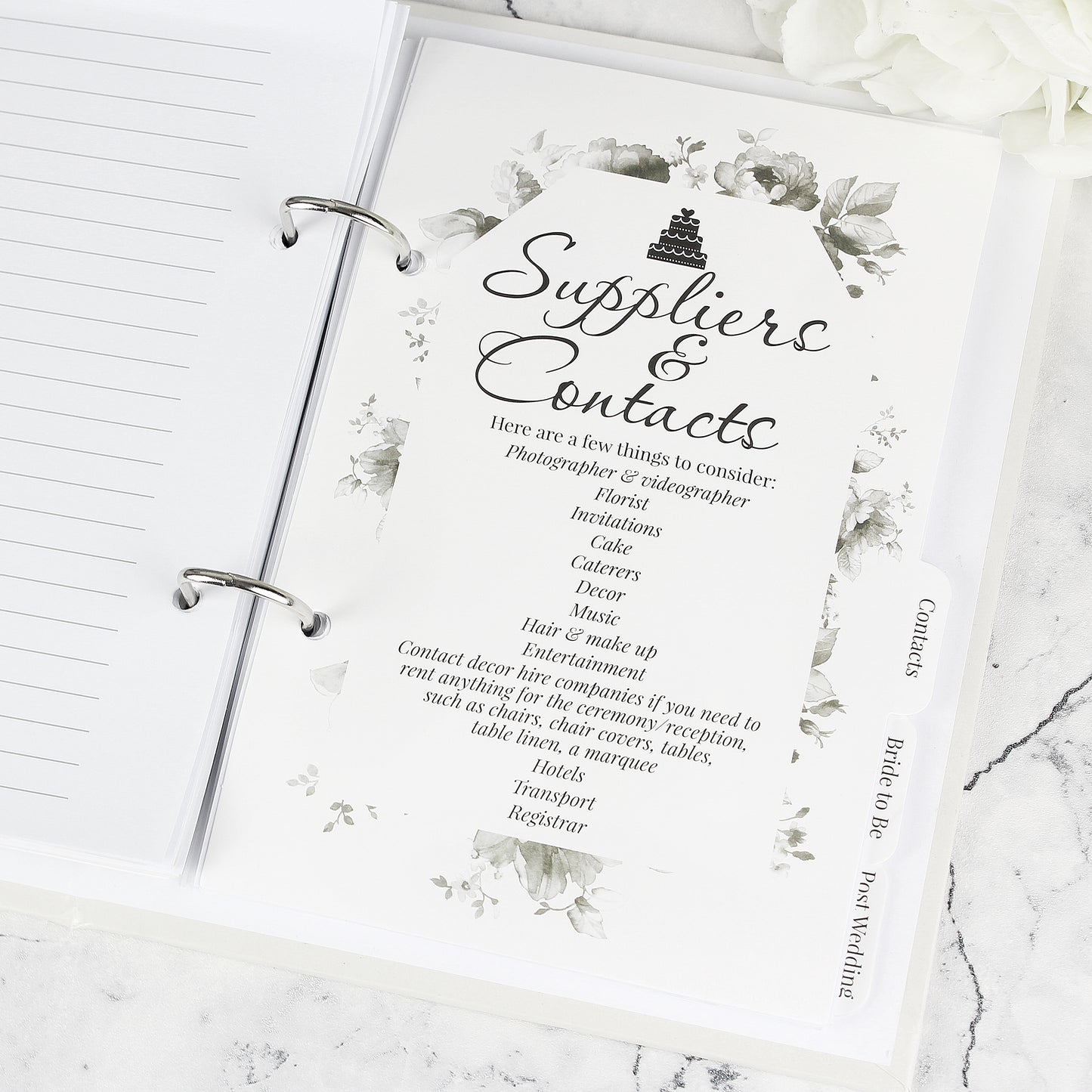 Sheet titled 'Suppliers & Contacts' in a planner with floral design on a marble surface.