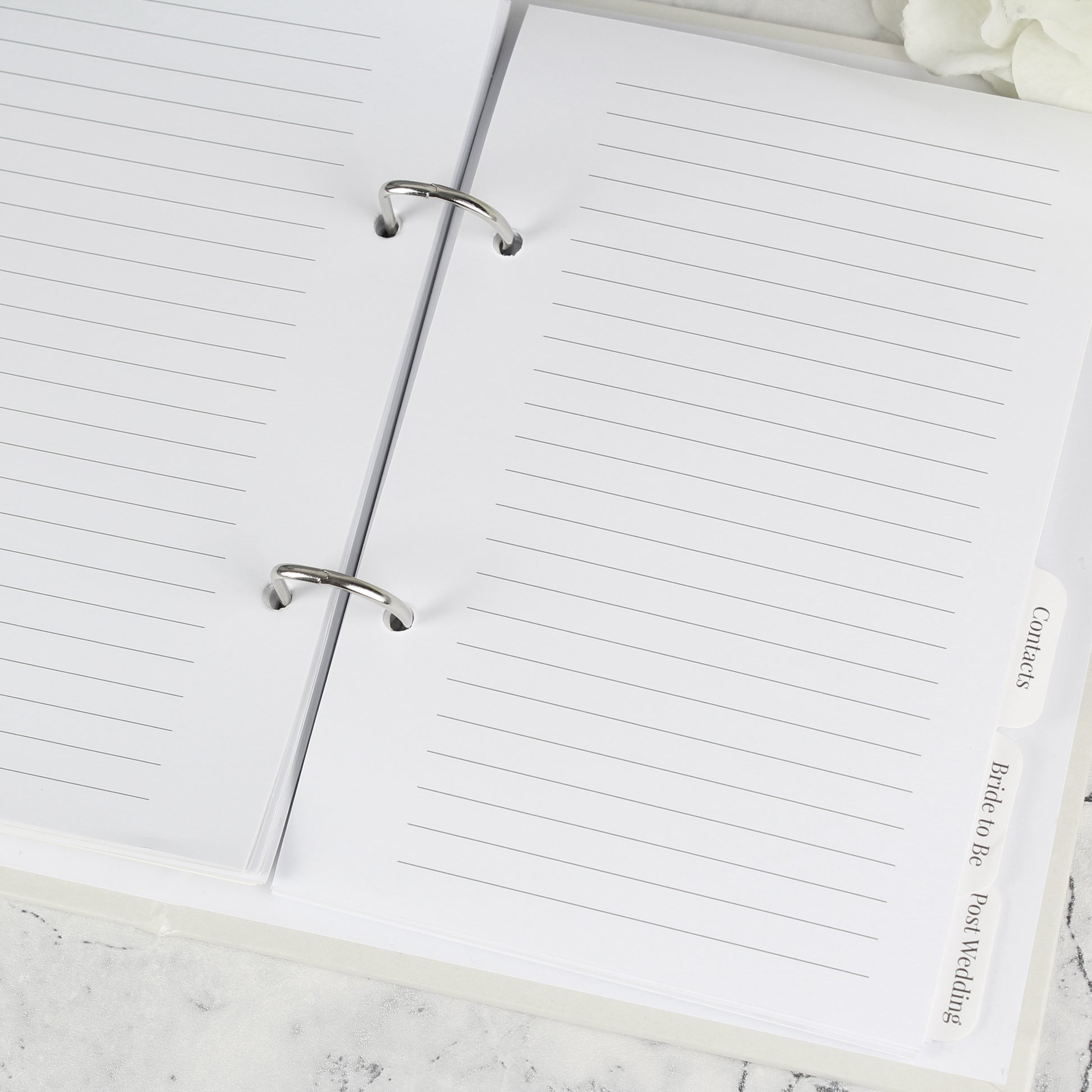 Open notebook with lined pages on a marble surface