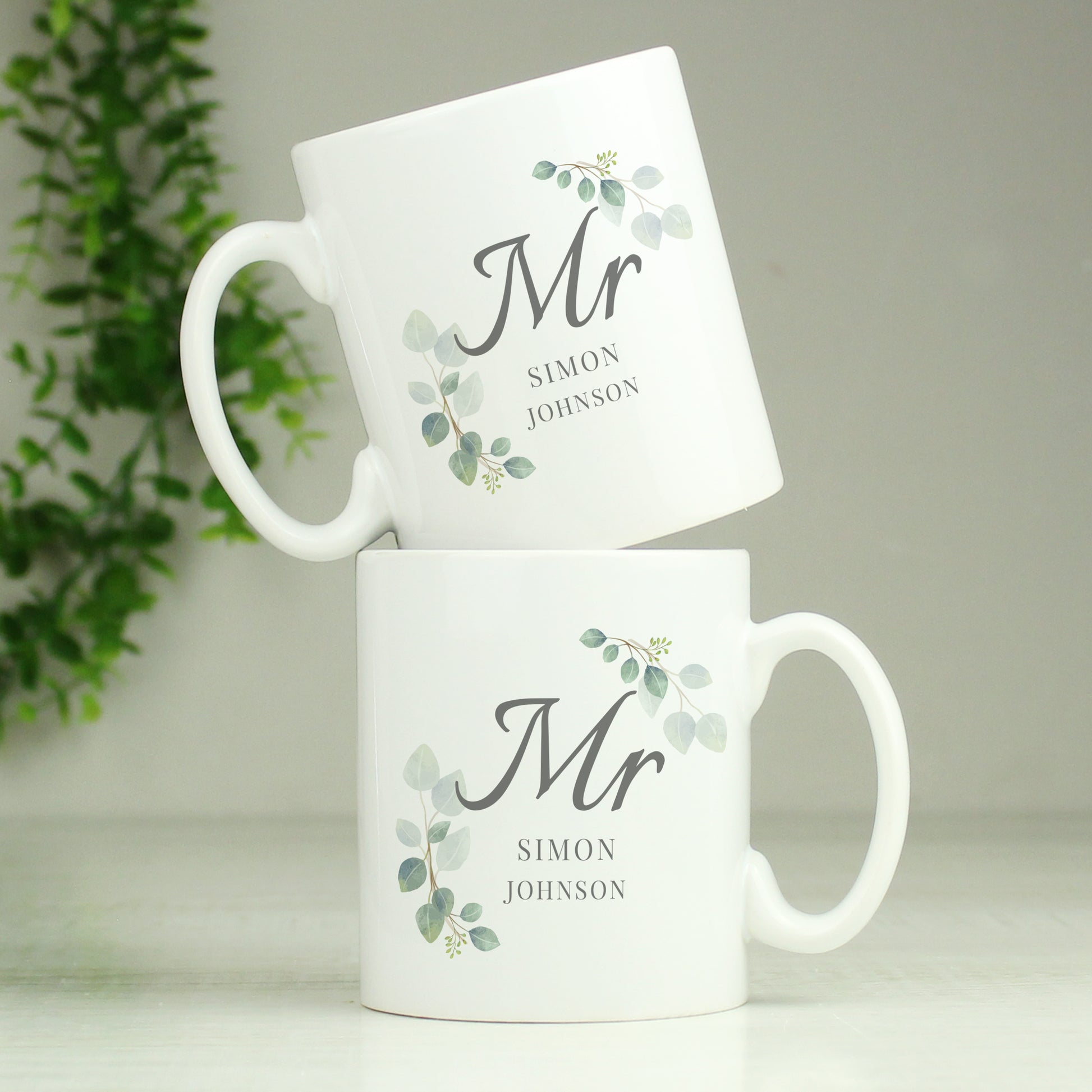 Two white mugs with 'Mr' and personalised names on a light background