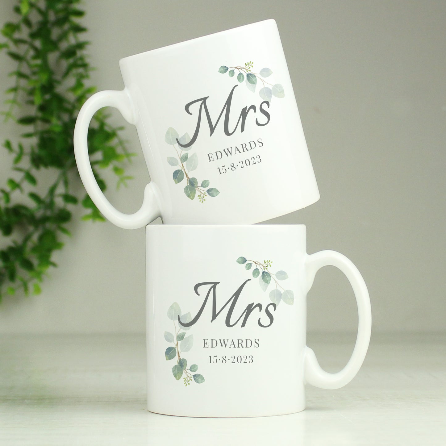 Two white mugs with 'Mrs' and personalised text on a light background