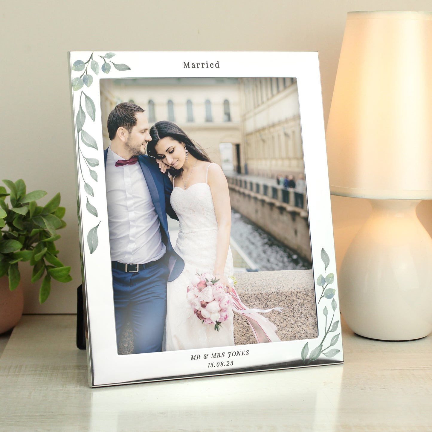 Silver frame with leaf decoration showing wedding photo. Personalised with Married above the photo and Mr & Mrs Jones 15.08.23 below it.