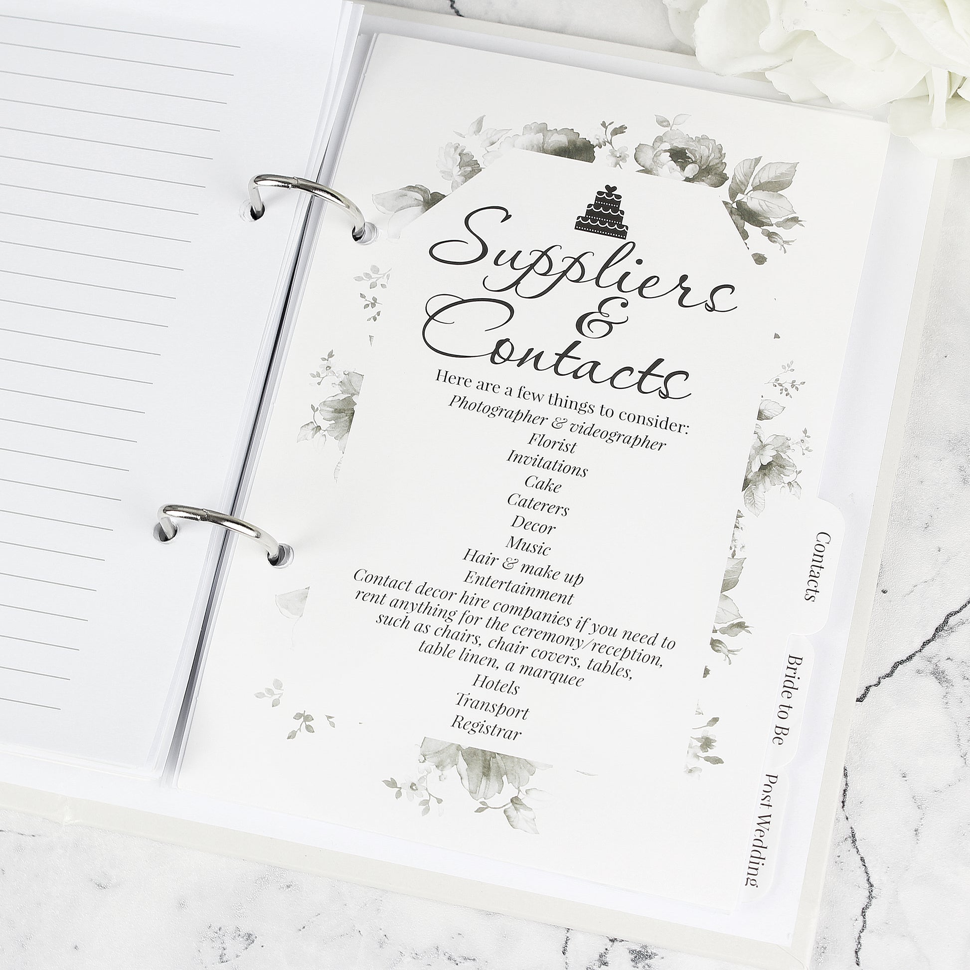 Sheet titled 'Suppliers & Contacts' in a planner with floral design on a marble surface.