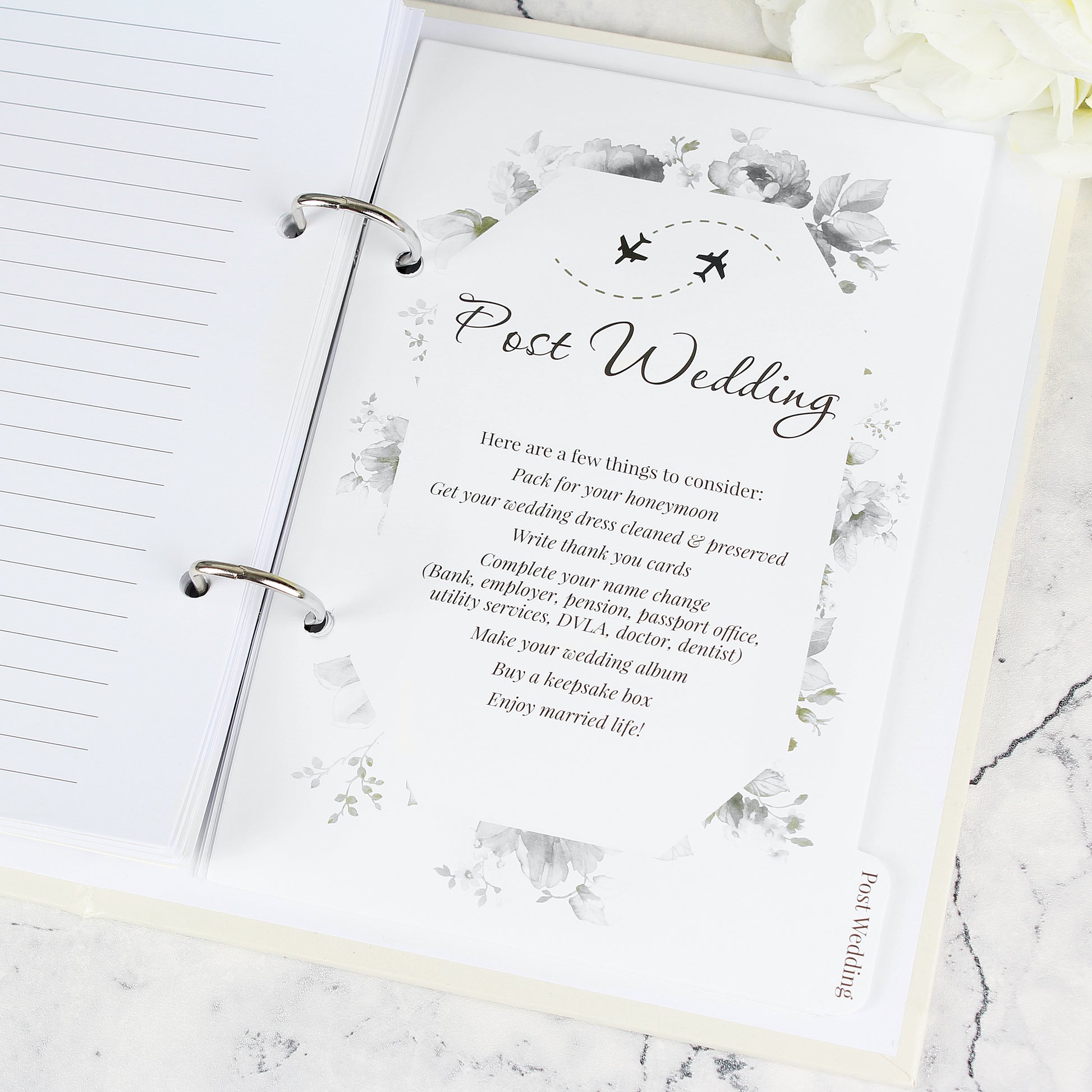 Notebook with a post-wedding checklist on a marble surface