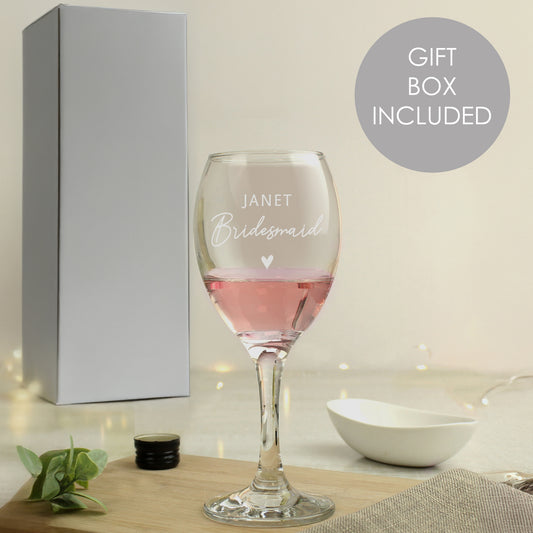 Wine glass with engraved text 'Janet Bridesmaid' in a gift box setting.