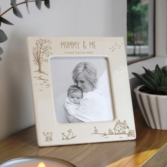 Photo frame with 'Mummy & Me' personalisation on a wooden surface with plants in the background