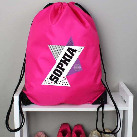 Pink drawstring bag with 'SOPHIA' design on a white shelf against a gray wall.