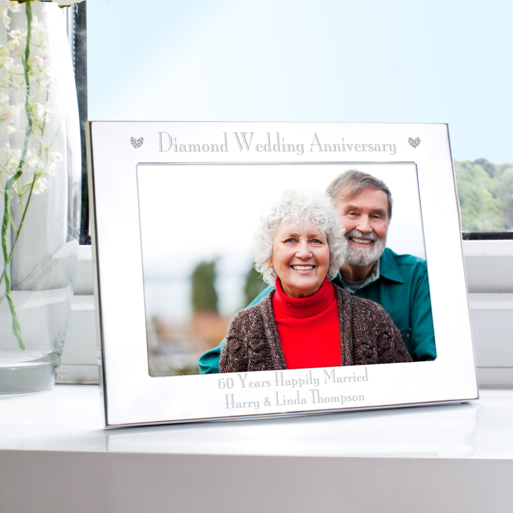 Personalised diamond wedding anniversary photo frame with a couple's portrait on a table.