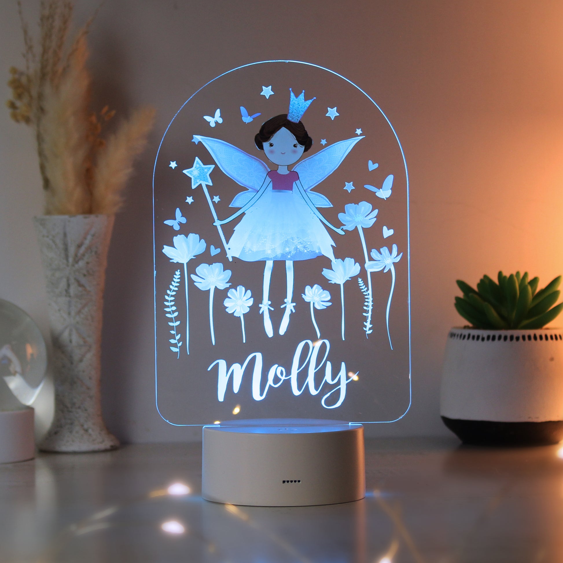 Fairy-themed night light with 'Molly' on a table with decorative plants.