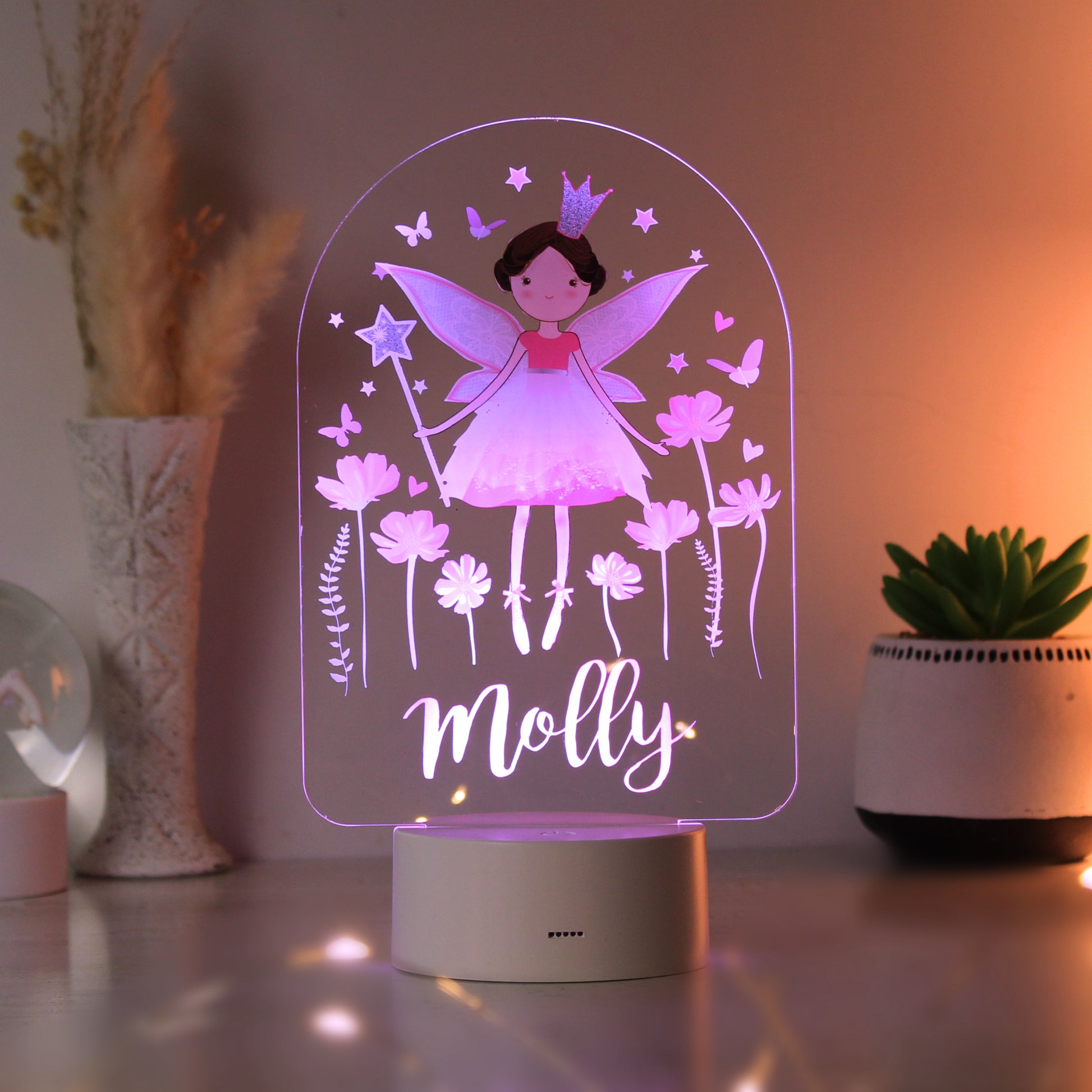Fairy-themed night light with 'Molly' on a table with decorative plants.
