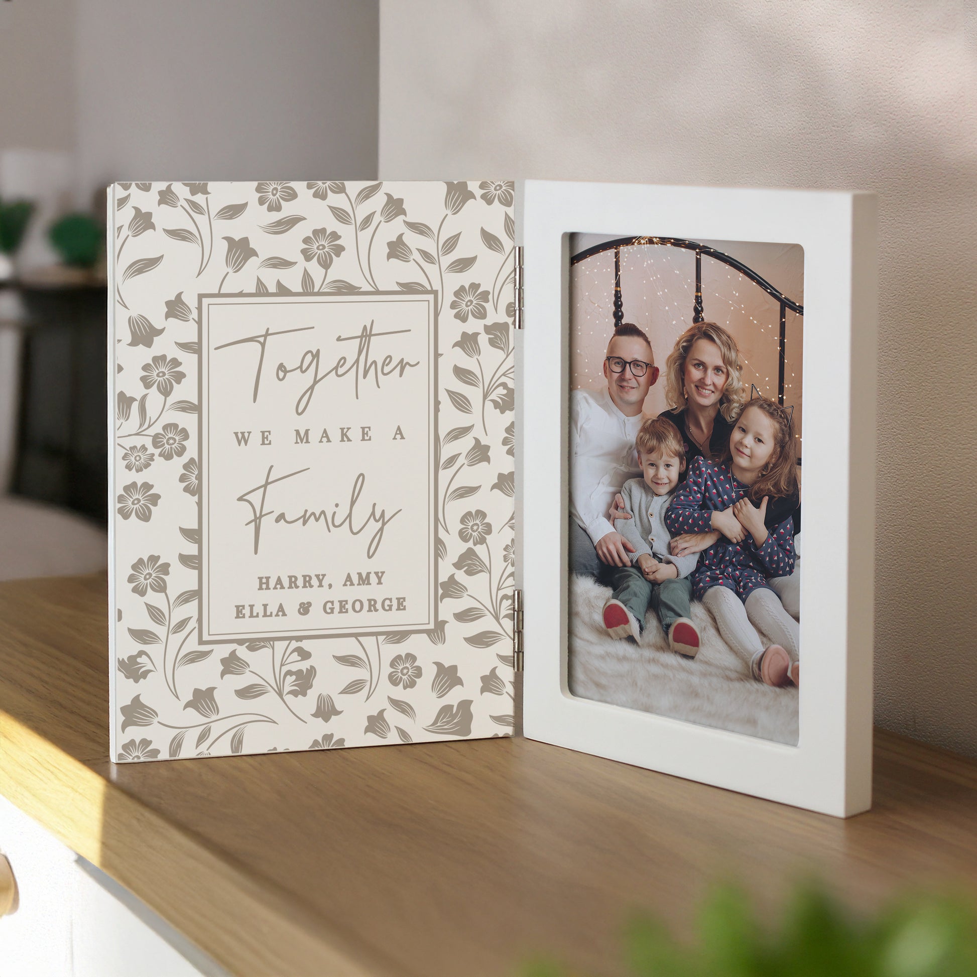 Personalised photo album with floral design and family photo on a wooden surface.
