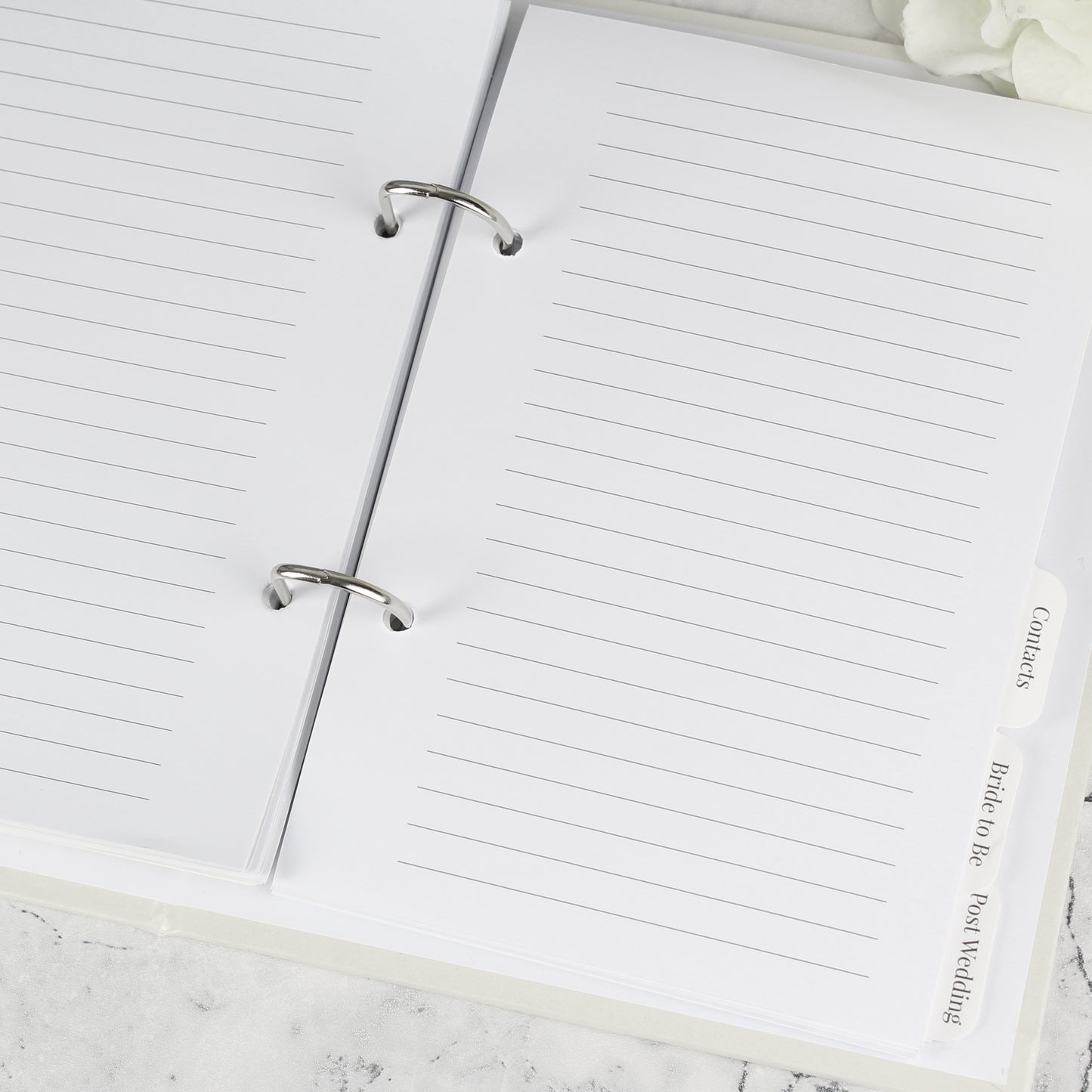 Open notebook with lined pages on a marble surface