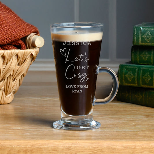 Personalised glass mug with coffee and engraved text on a wooden surface.