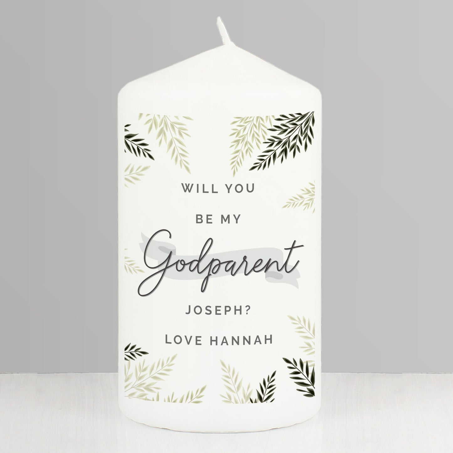 White candle with 'Will you be my Godparent' text and leaf patterns on a gray background