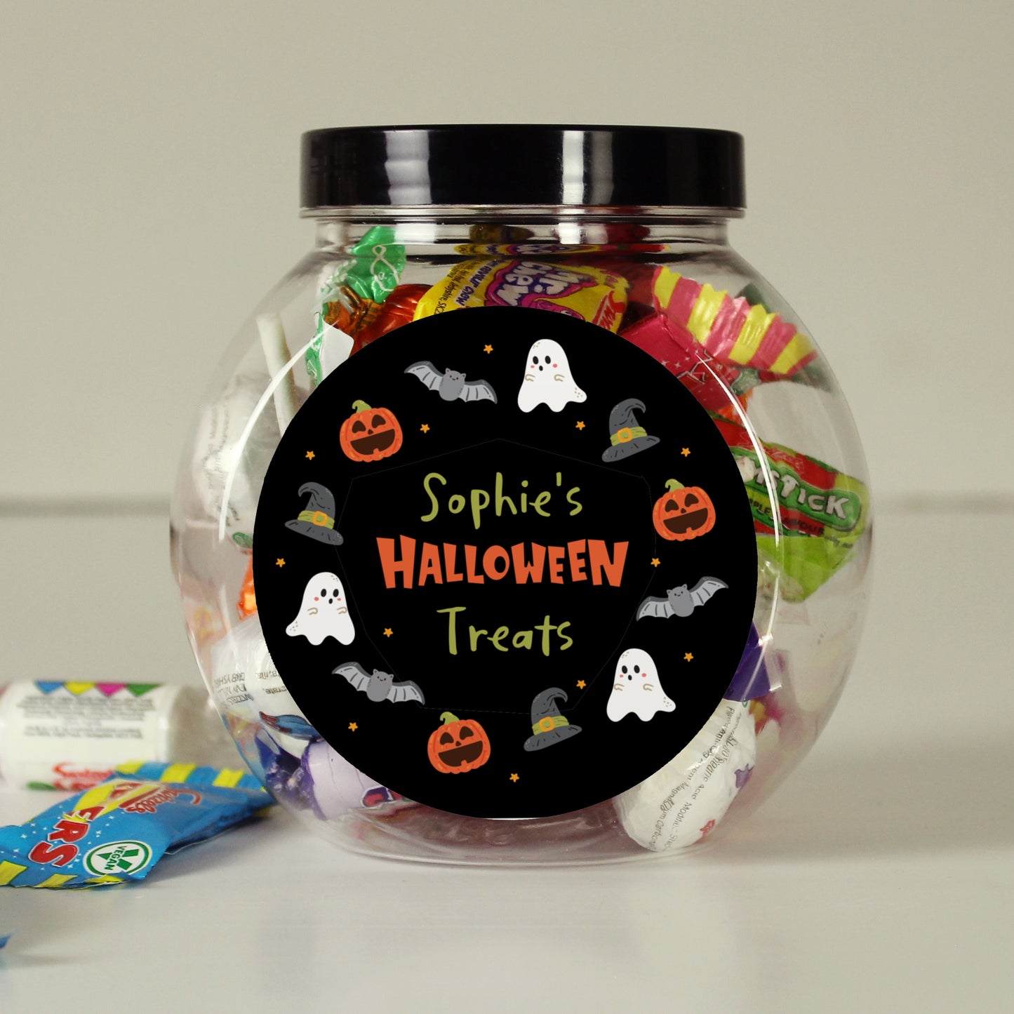 Jar of Halloween treats with a personalised label on a neutral background