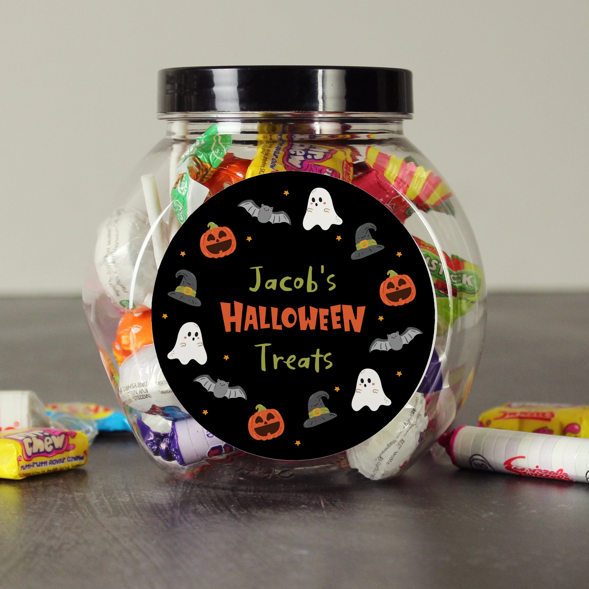 Jar of Halloween treats with a personalised label on a neutral background