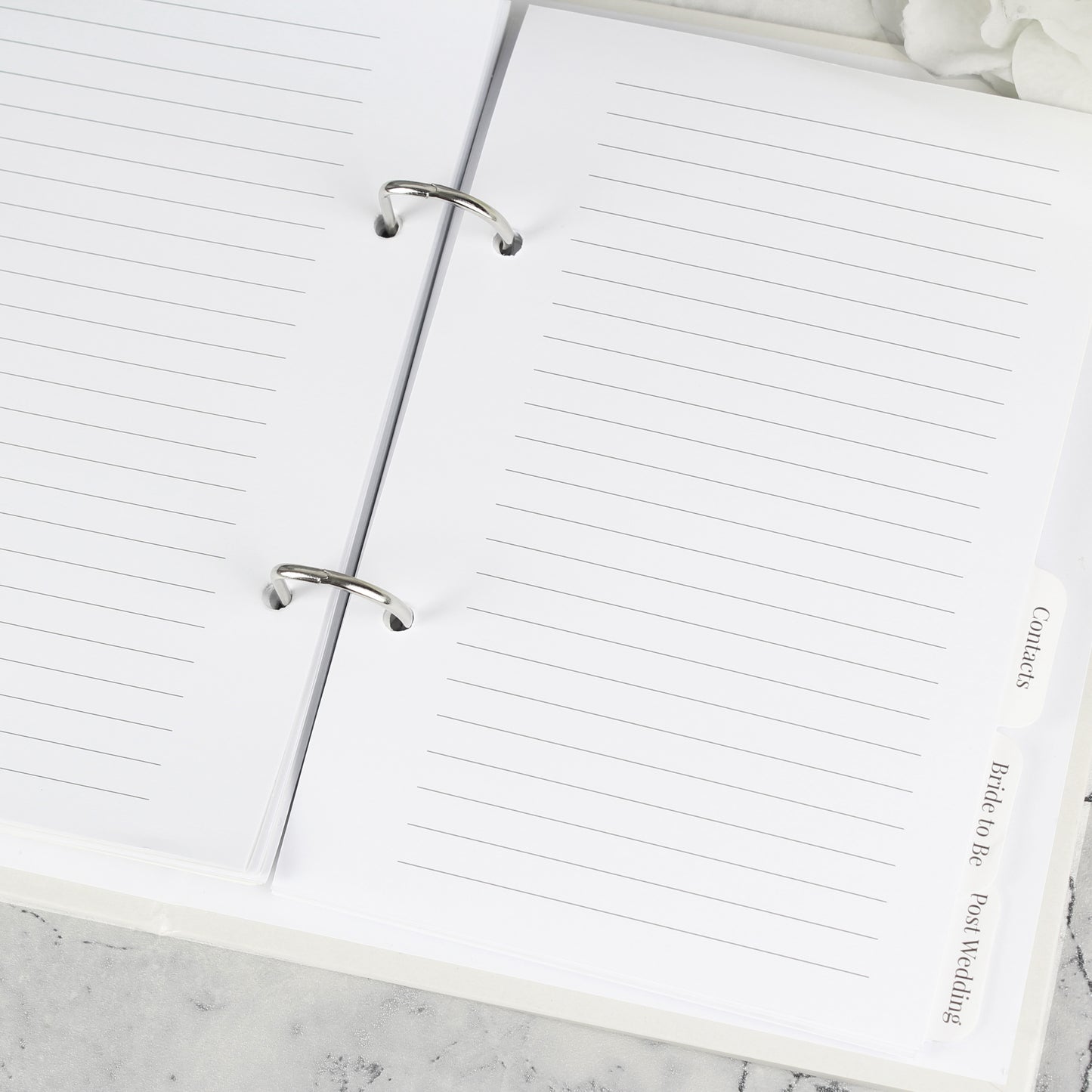 Open notebook with lined pages on a marble surface