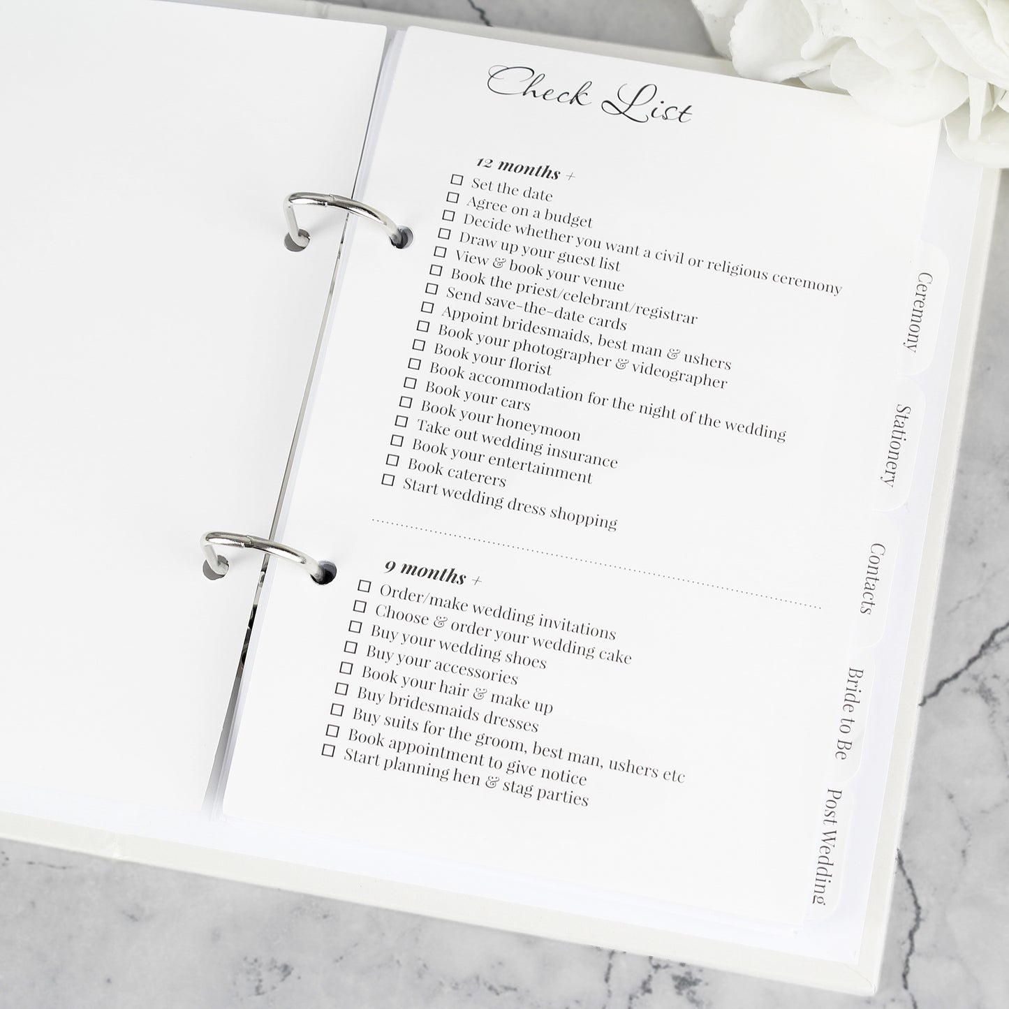 Wedding planning checklist on a marble surface