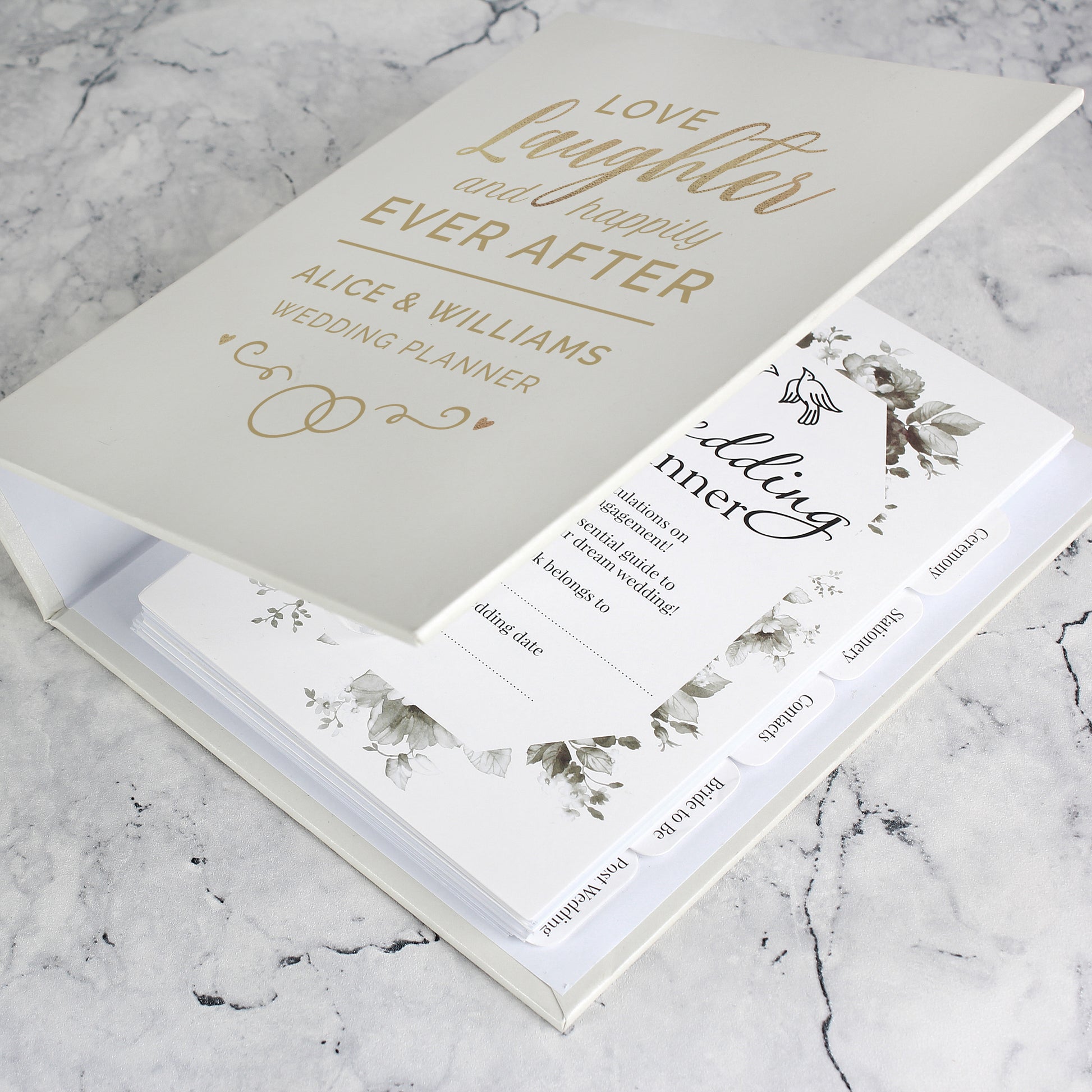 Wedding planner book with floral design on a marble surface