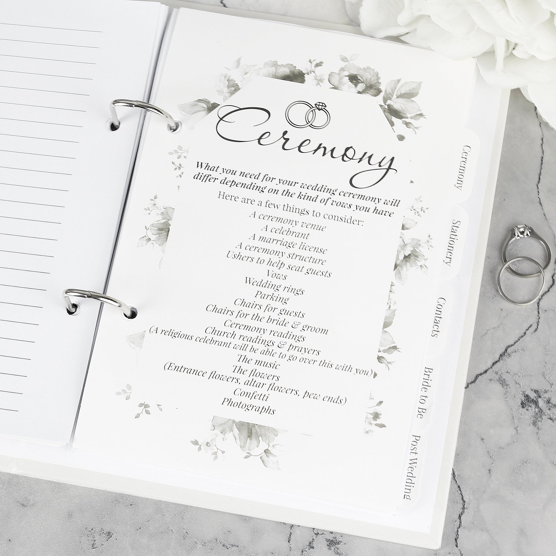 Wedding planner book with 'Ceremony' section on a marble surface
