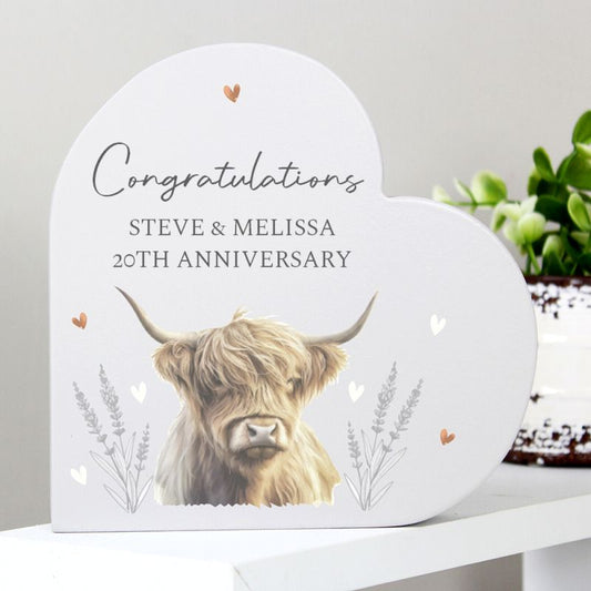 Plaque with a highland cow illustration and 'Congratulations Steve & Melissa 20th Anniversary' text on a white surface.