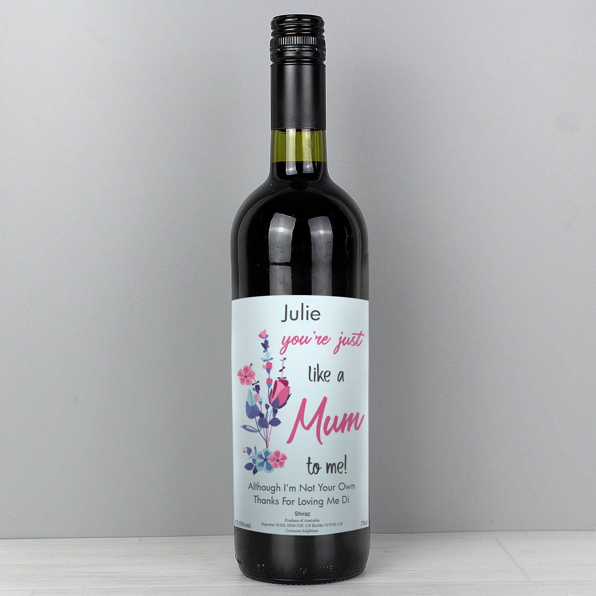 Wine bottle with a personalised label on a grey background