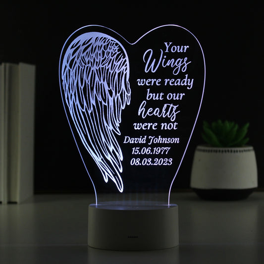 Heart-shaped night light with angel wings and personalised text on a dark background