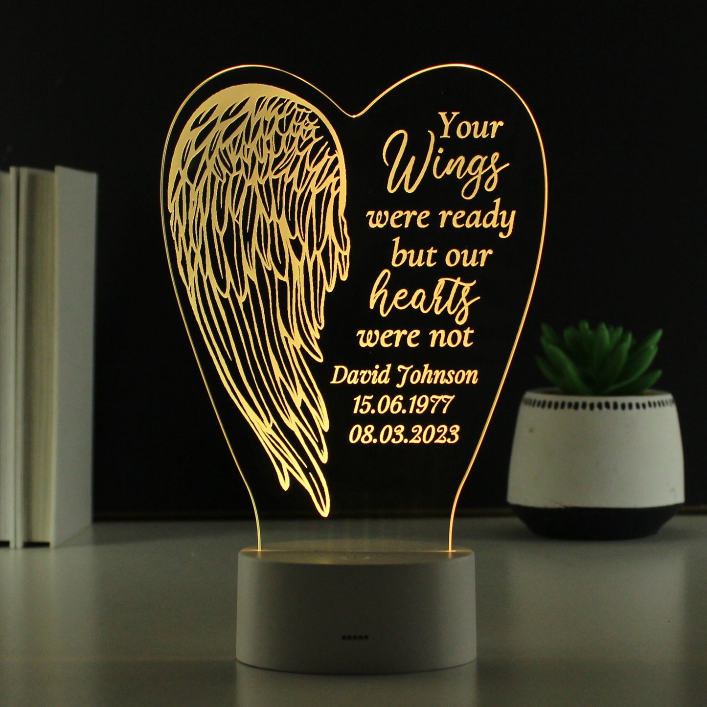 Decorative lamp with angel wing design and personalised text on a dark background
