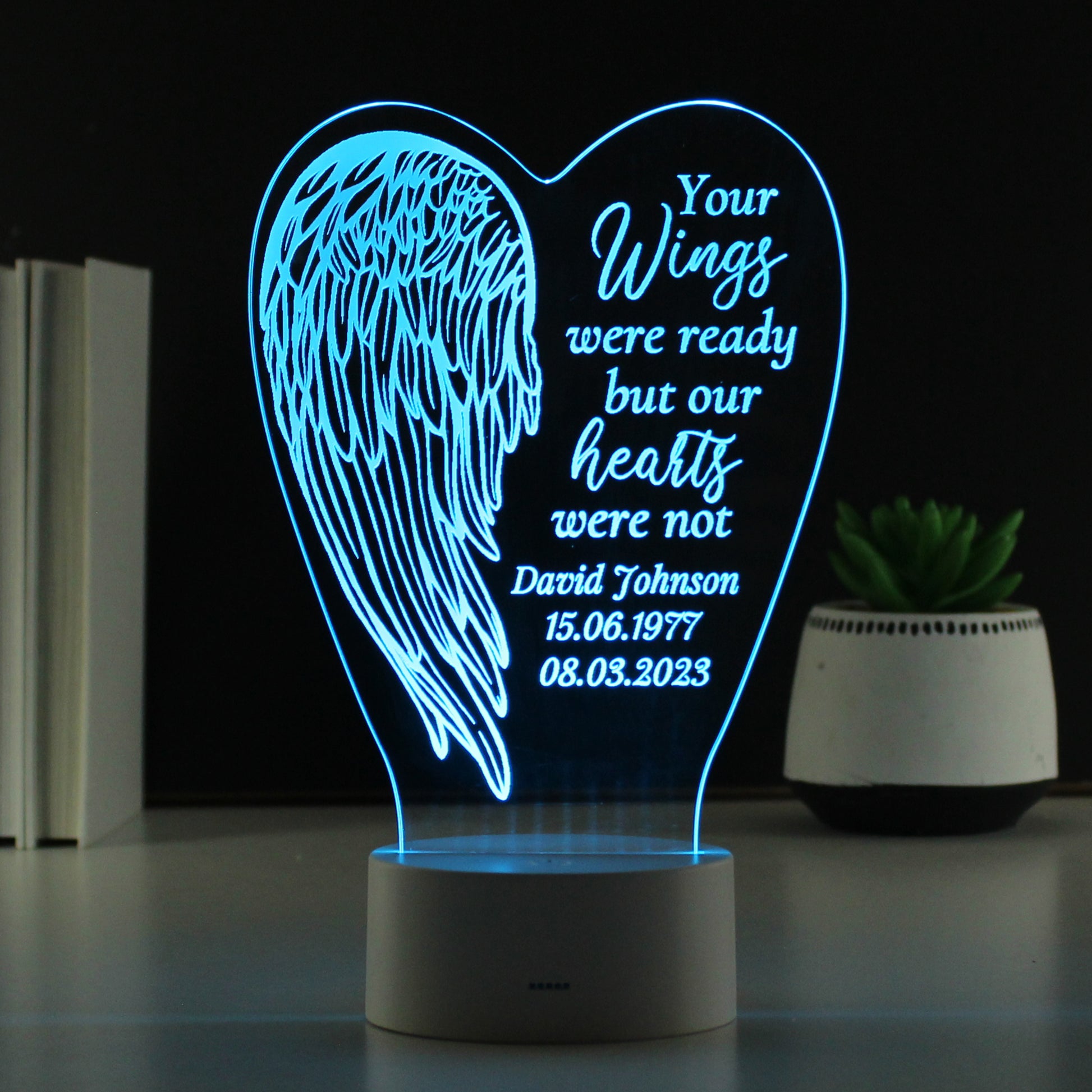 LED lamp with angel wing design and personalised text on a dark background