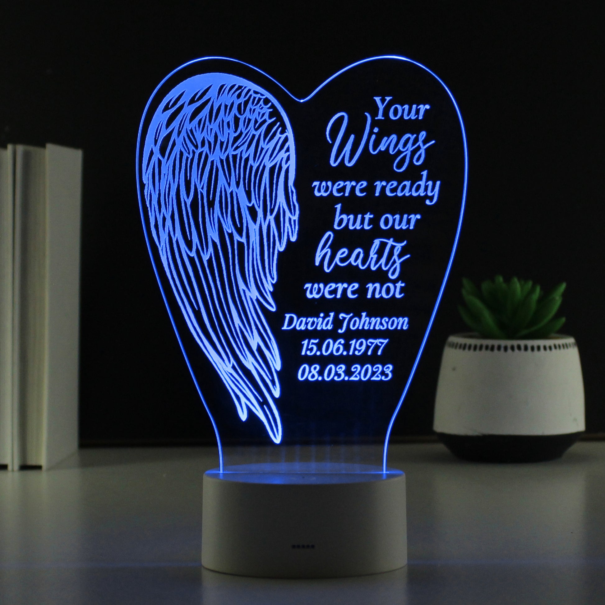Heart-shaped night light with angel wing design and personalised text on a dark background.