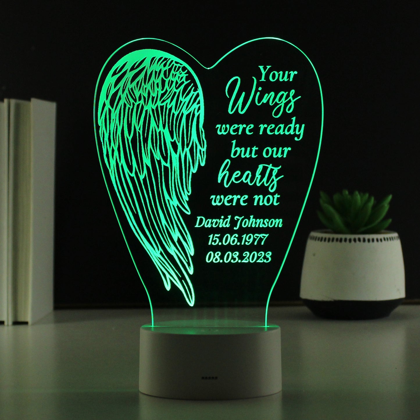 LED lamp with angel wing design and text on a dark background