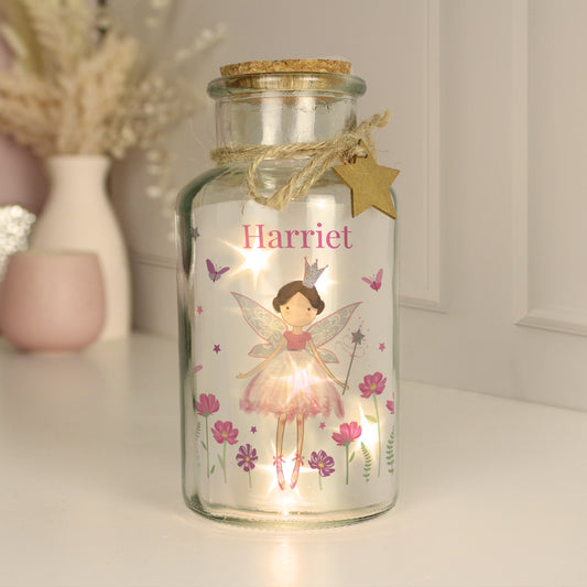Decorative glass jar with fairy design and 'Harriet' text, featuring a light inside.