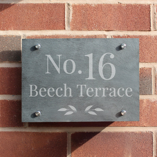Slate house number sign with 'No. 16 Beech Terrace' on a brick wall.
