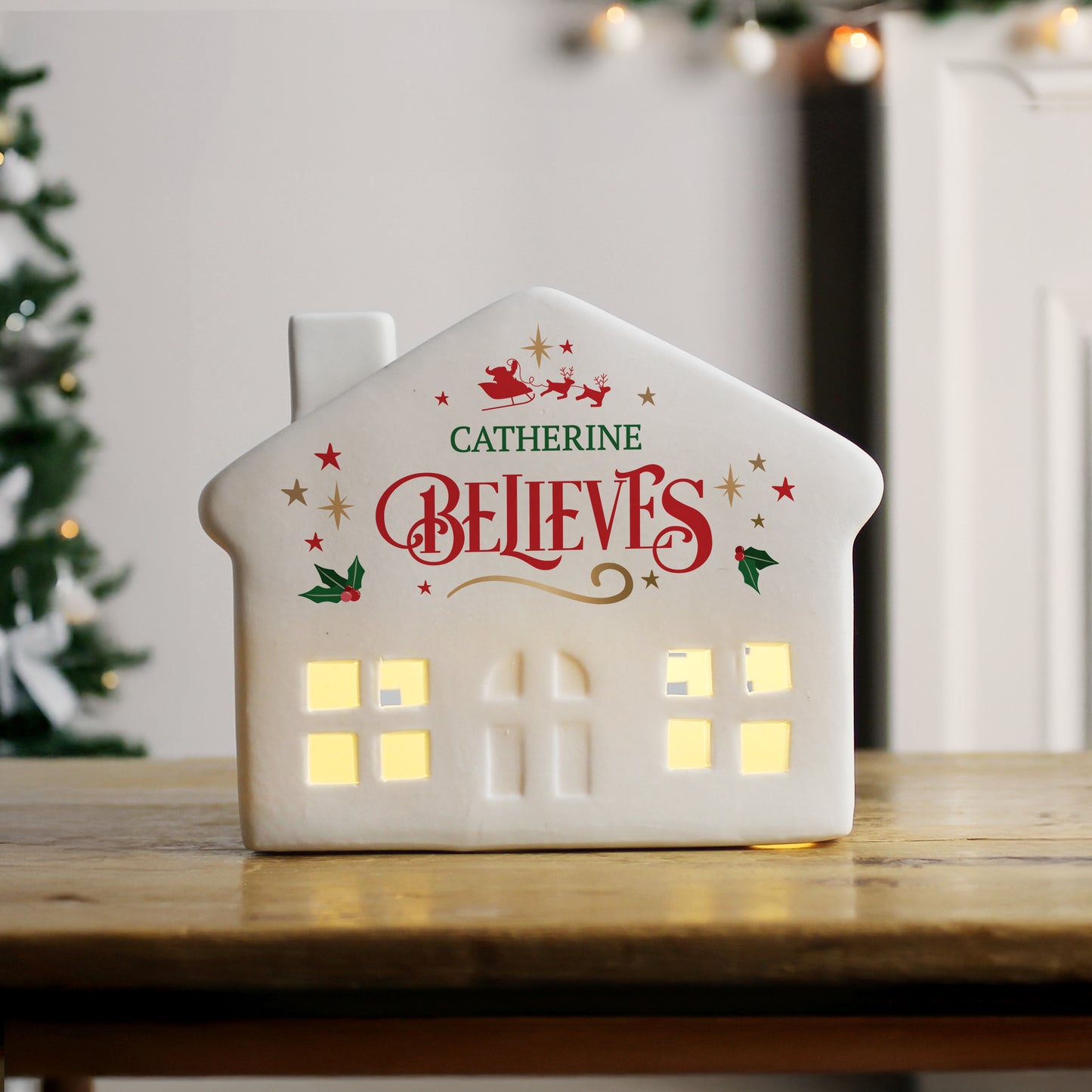 White LED Christmas house, front facing with personalised text and holly and star images.