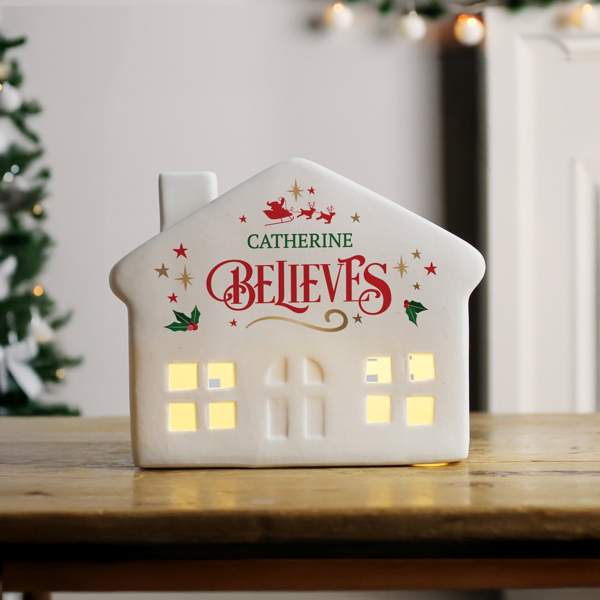 White LED Christmas house, front facing with personalised text and holly and star images.