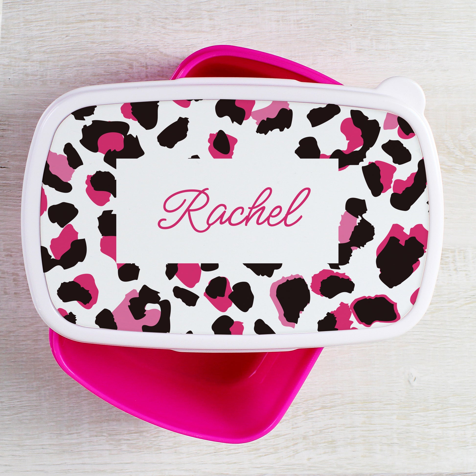 Leopard print lunch bag with pink accents and 'Rachel' name on a light wooden surface