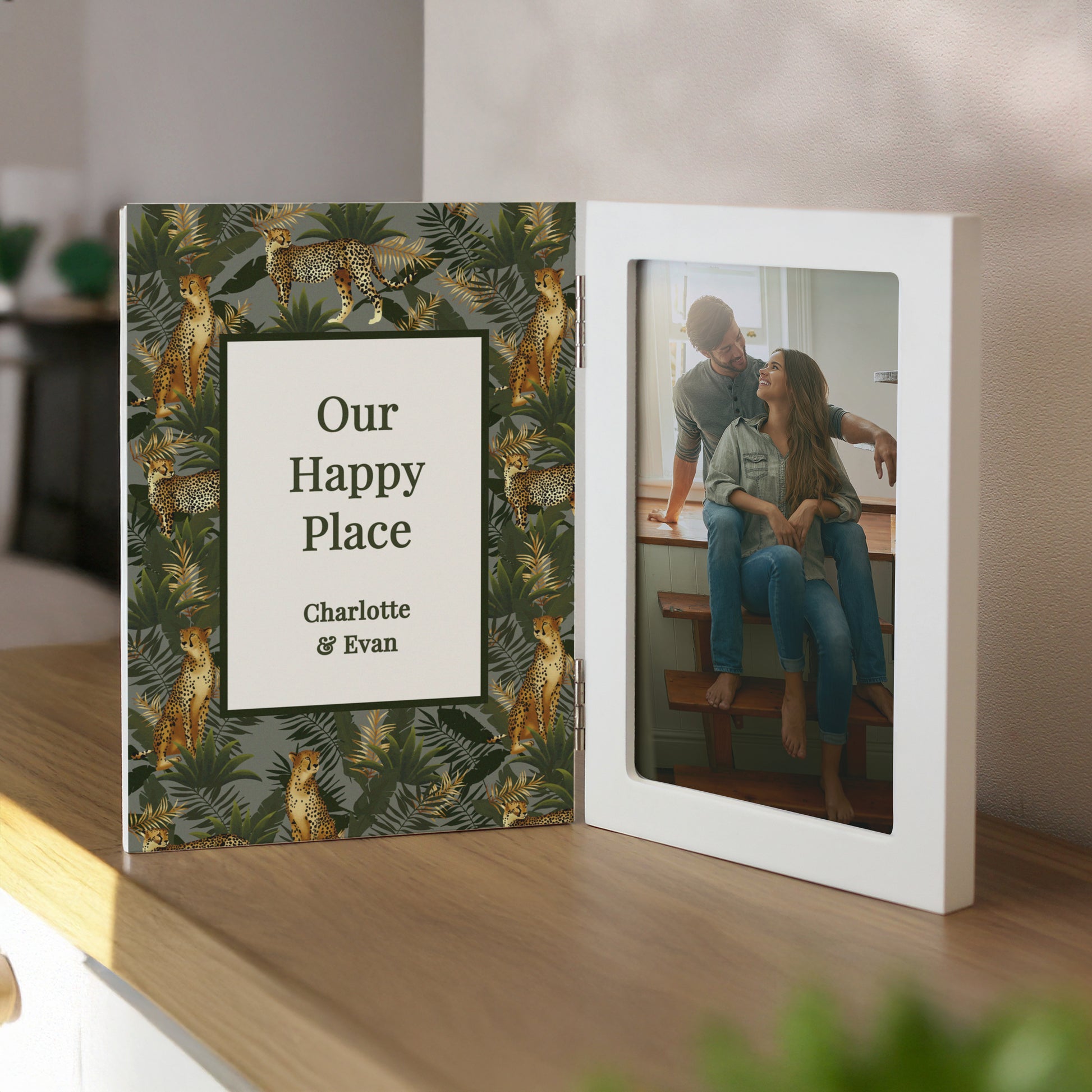 Personalised photo album with jungle leaf design and couple, on a shelf.