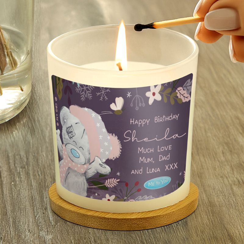 Candle being lit with a personalised label featuring a cartoon character on a wooden surface.