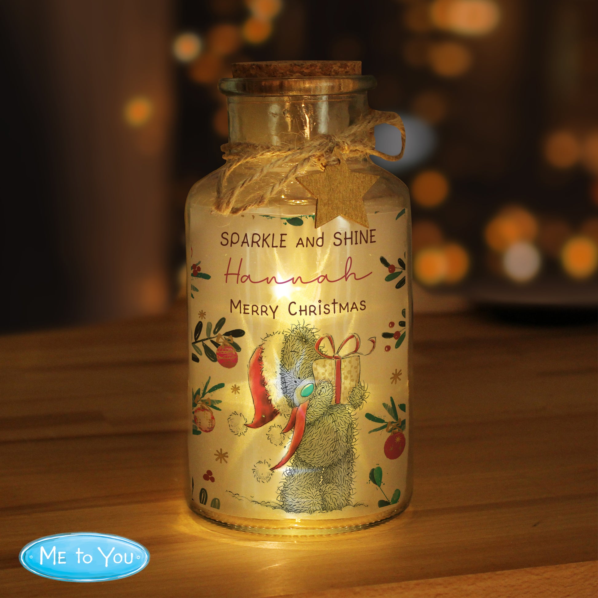 Decorative glass jar with a teddy bear design and 'Me to You' branding, glowing warmly on a wooden surface.