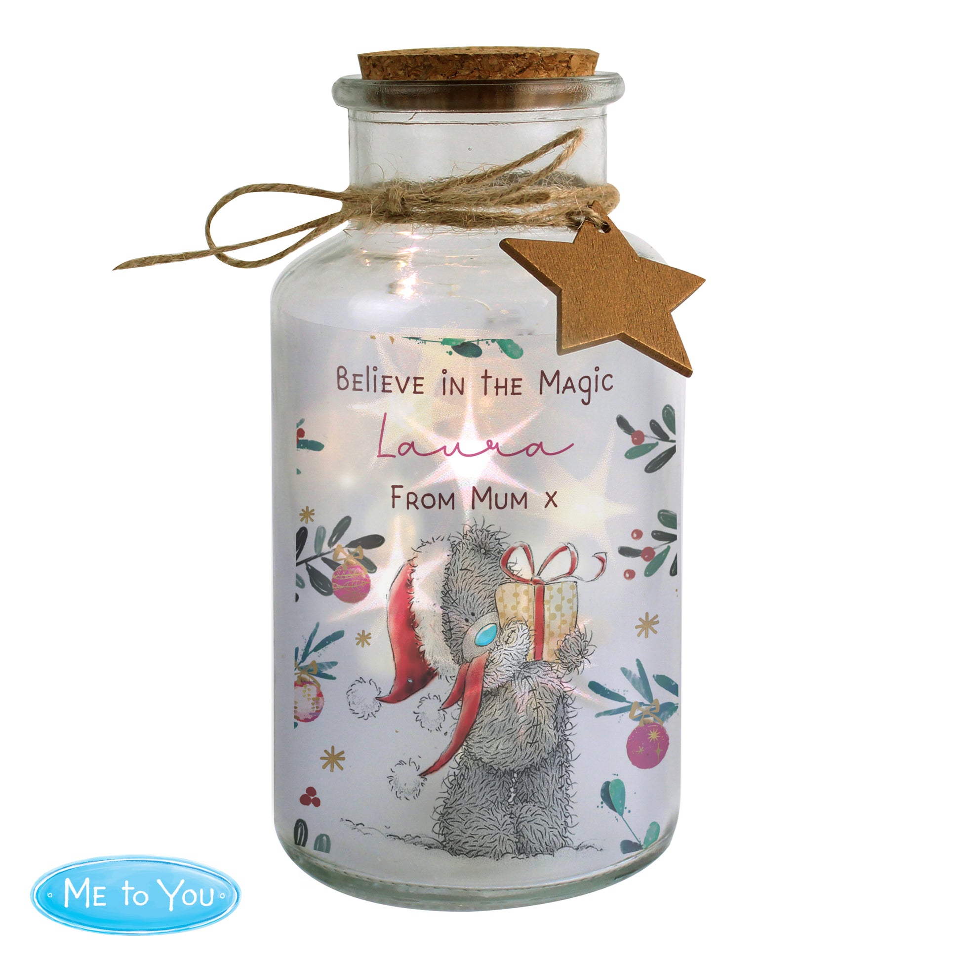 Decorative glass jar with a teddy bear holding a gift, featuring text and a star tag on a white background.