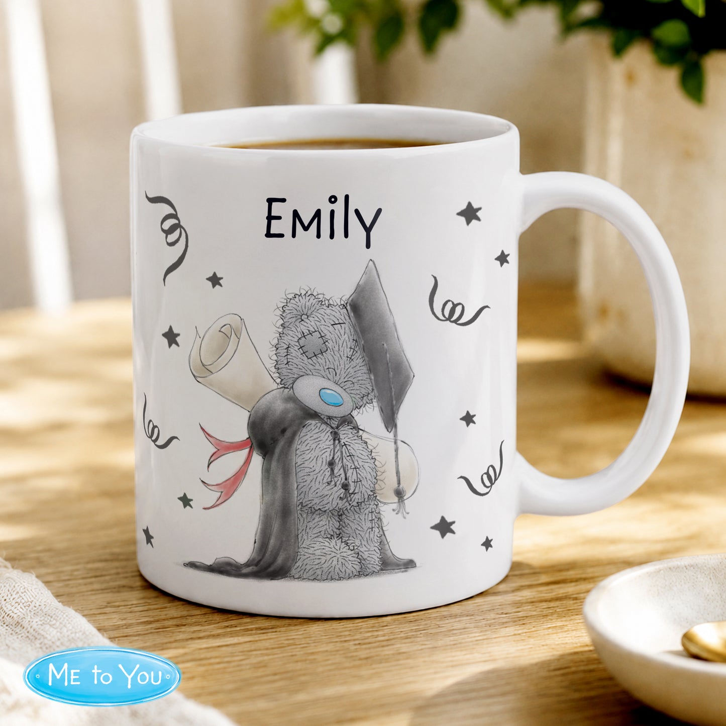 White mug with a cartoon character and 'Emily' text on a wooden table.