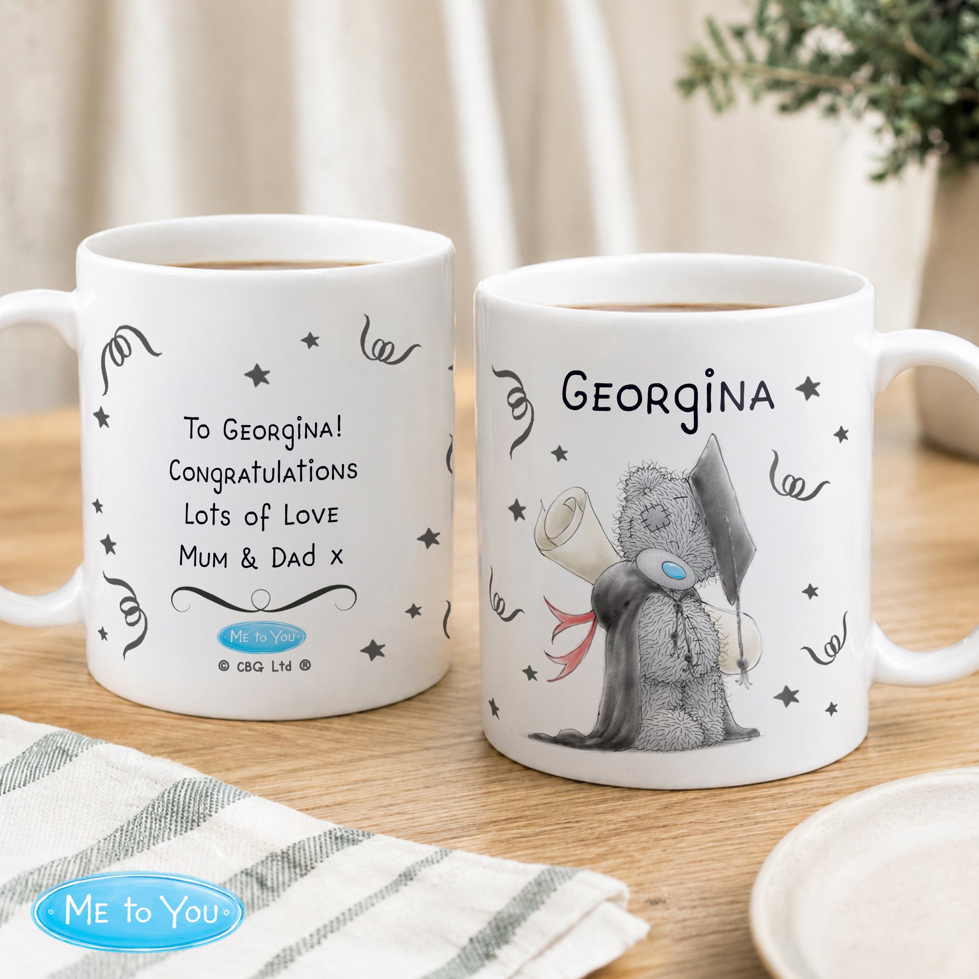 Two mugs with personalized messages on a wooden surface, featuring a character from 'Me to You'.