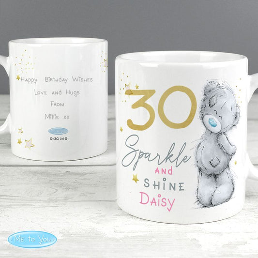 Back and front of white mug with personalised text and a teddy bear design on a wooden surface.