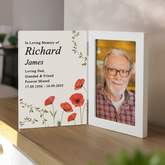Memorial frame with photo and text of an elderly man on a wooden surface.