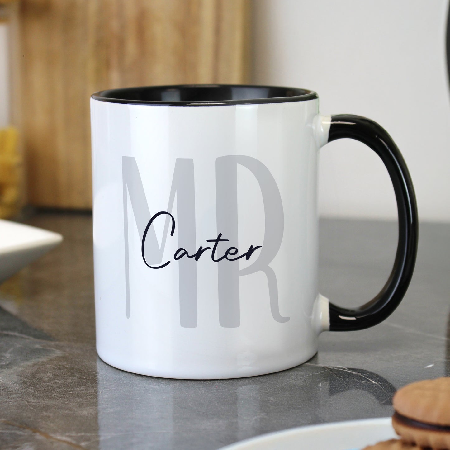 White mug with black interior and handle, featuring 'MR Carter' text, on a kitchen counter.